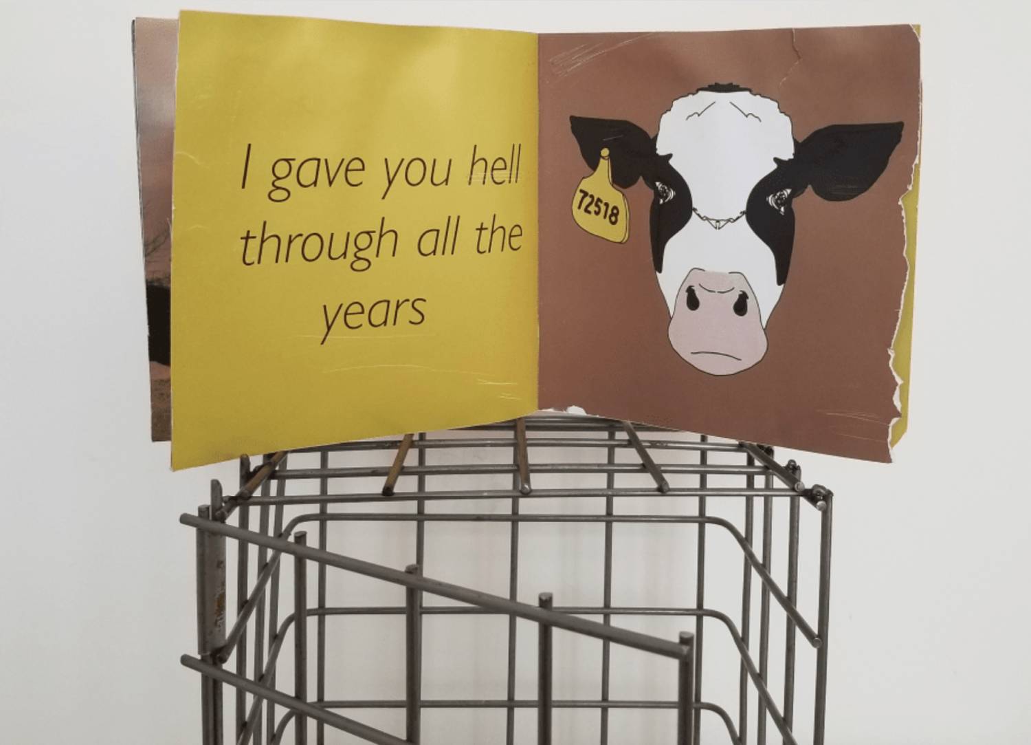 booklet showing a cow & song lyrics atop a self-made steel cage